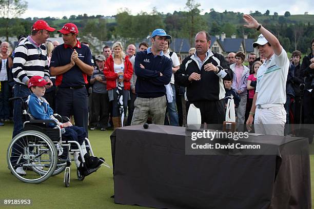 Rory McIlroy of Nortehrn Ireland waves to the crowds at the presentation, watched by Jim Treacy the owner of Lough Erne, James Nesbitt the actor,...