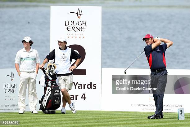 Padraig Harrington of Ireland hits his tee shot at the 2nd hole watched by Rory McIlroy of Northern Ireland during the Lough Erne Challenge, on the...
