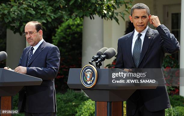 President Barack Obama and Iraqi Prime Minister Nuri al-Maliki listen a question during a joint press conference following their meeting at the Rose...