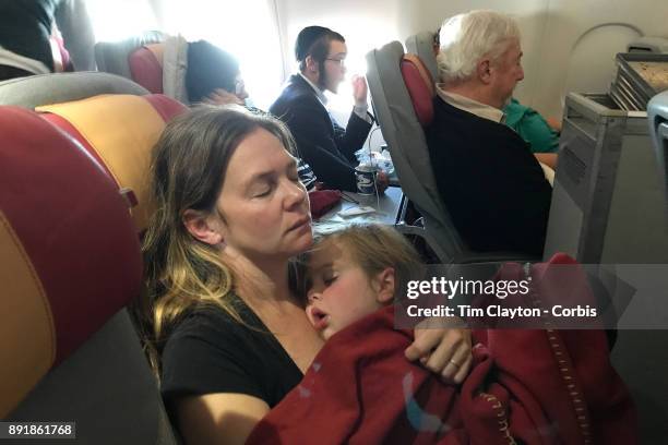 Mother with her sleeping three year old daughter on a flight from New York to Rome. Italy. 22nd October 2017. Photo by Tim Clayton/Corbis via Getty...