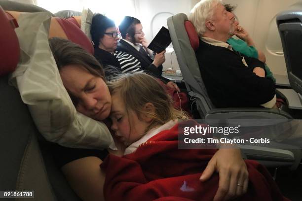 Mother with her sleeping three year old daughter on a flight from New York to Rome. Italy. 22nd October 2017. Photo by Tim Clayton/Corbis via Getty...