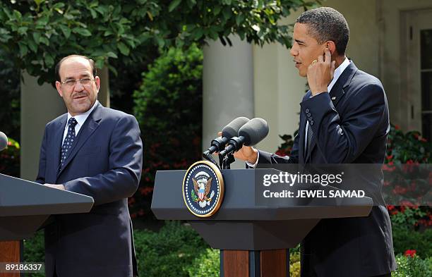 President Barack Obama waits to have a question translated as Iraqi Prime Minister Nuri al-Maliki looks on during a joint press conference following...