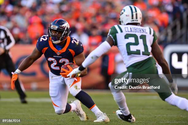 Running back C.J. Anderson of the Denver Broncos rushes under coverage by cornerback Morris Claiborne of the New York Jets at Sports Authority Field...