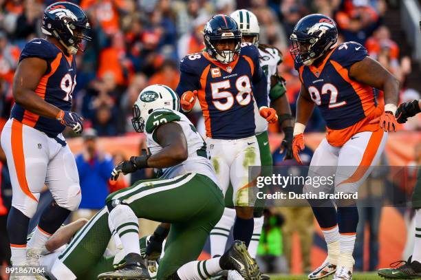 Outside linebacker Von Miller of the Denver Broncos celebrates along with Shelby Harris and nose tackle Zach Kerr after a sack against the New York...