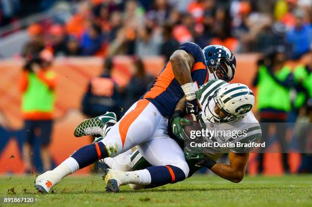 Running back Matt Forte of the New York Jets is hit by defensive back Will Parks of the Denver Broncos at Sports Authority Field at Mile High on...
