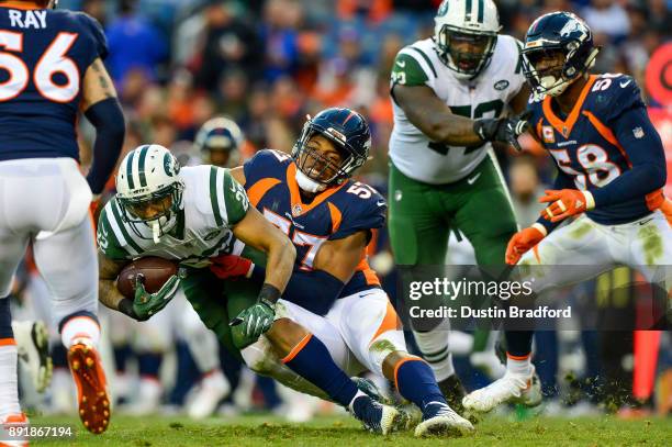 Defensive end DeMarcus Walker of the Denver Broncos stops running back Matt Forte of the New York Jets int he fourth quarter of game at Sports...