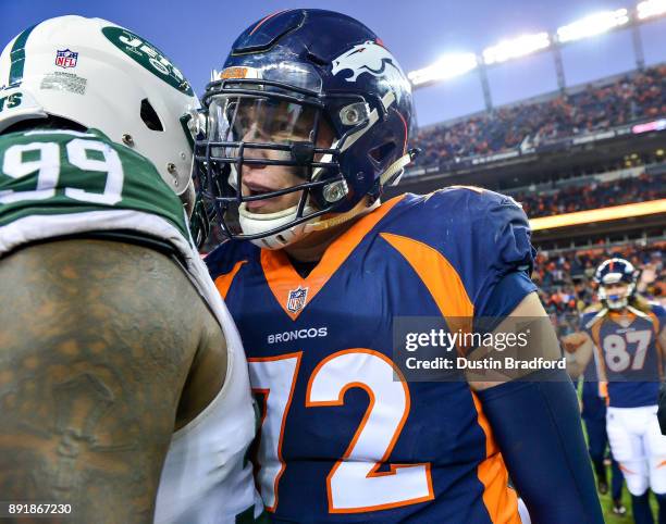 Offensive tackle Garett Bolles of the Denver Broncos has a word with nose tackle Steve McLendon of the New York Jets on the field after a game at...