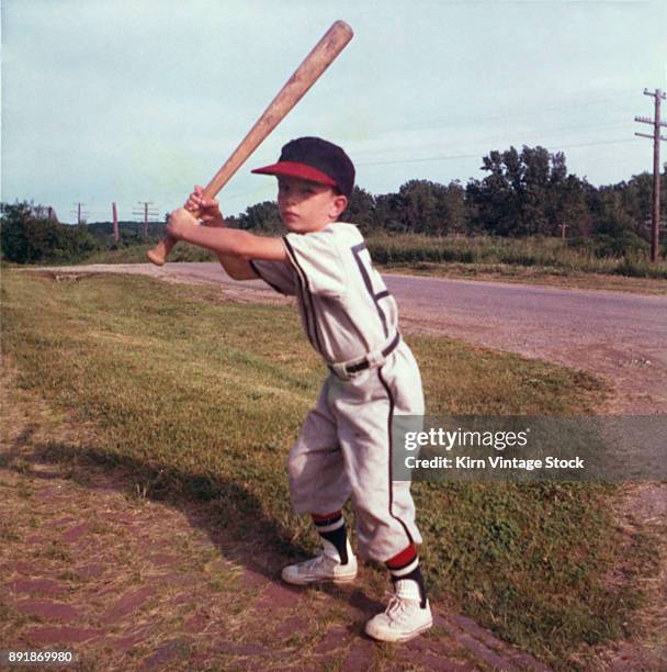 Little leaguer adopts a batting stance, ready with his baseball bat.