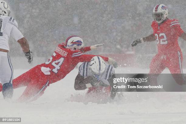 Marlon Mack of the Indianapolis Colts runs with the ball as he is tackled by Tre'Davious White of the Buffalo Bills and Eddie Yarbrough during NFL...
