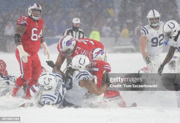 LeSean McCoy of the Buffalo Bills is tackled by Jabaal Sheard of the Indianapolis Colts and Antonio Morrison as heavy snow falls during NFL game...