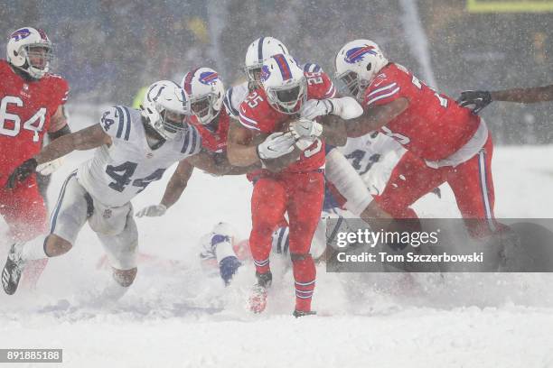 LeSean McCoy of the Buffalo Bills is tackled by Jabaal Sheard of the Indianapolis Colts and Antonio Morrison as heavy snow falls during NFL game...