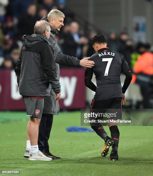 Arsenal manager Arsene Wenger past Alexis Sanchez on the back after his substitution during the Premier League match between West Ham United and...