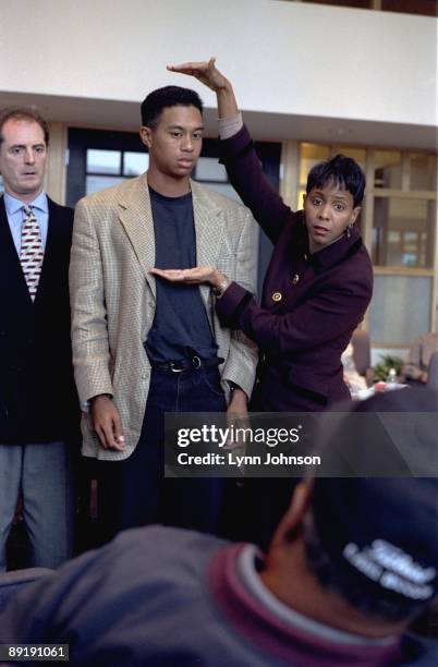 Casual portrait of Tiger Woods being sized up by media expert Denise Harrington at Nike Headquarters. Beaverton, OR CREDIT: Lynn Johnson