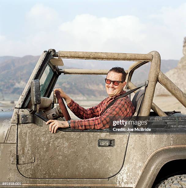 man covered in mud driving sports  vehicle - dirty car stock-fotos und bilder