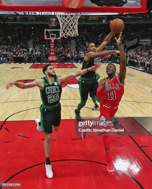 David Nwaba of the Chicago Bulls puts up a shot between Abdel Nader and Al Horford of the Boston Celtics at the United Center on December 11, 2017 in...