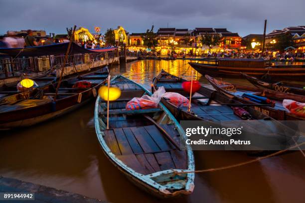 traditional boats in front of ancient architecture in hoi an, vietnam. - danang stock pictures, royalty-free photos & images