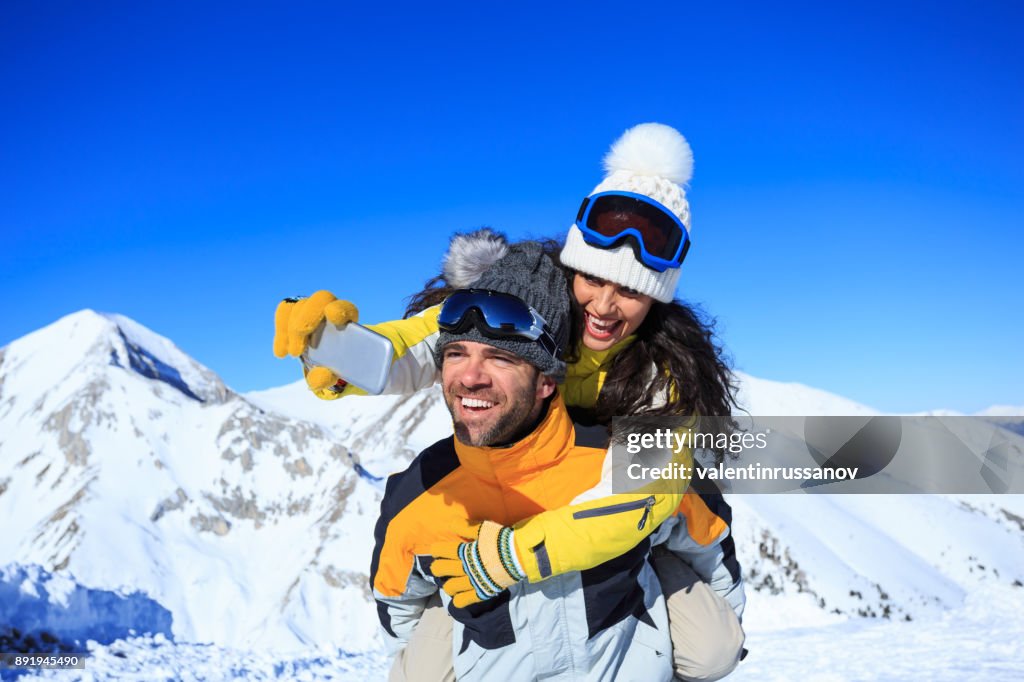 Junges Paar Skifahrer nehmen Selfie auf dem oberen Schneeberg