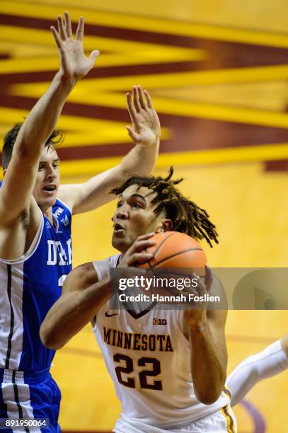 Reggie Lynch of the Minnesota Golden Gophers shoots the ball against Nick McGlynn of the Drake Bulldogs on December 11, 2017 at Williams Arena in...