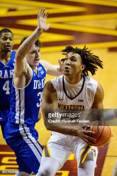 Reggie Lynch of the Minnesota Golden Gophers shoots the ball against Nick McGlynn of the Drake Bulldogs on December 11, 2017 at Williams Arena in...