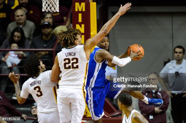 Rivers of the Drake Bulldogs passes the ball away from Jordan Murphy and Reggie Lynch of the Minnesota Golden Gophers during the game on December 11,...