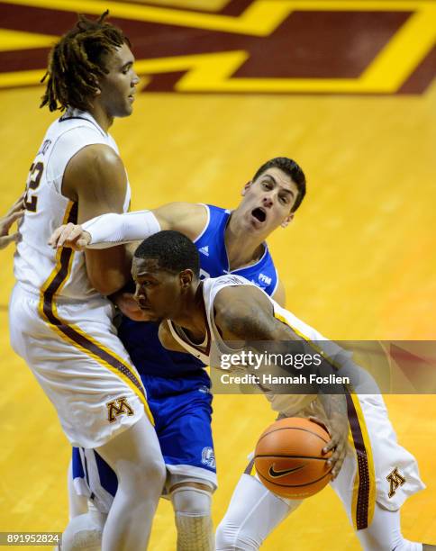 Reggie Lynch of the Minnesota Golden Gophers sets a pick for Reed Timmer of the Drake Bulldogs as teammate Dupree McBrayer drives to the basket...