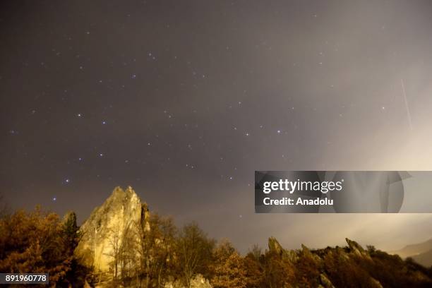 Meteors named as 'Geminid' streak across the sky over Abaci fairy chimneys located at Kizilcahamam district of Turkey's Ankara on December 14, 2017.