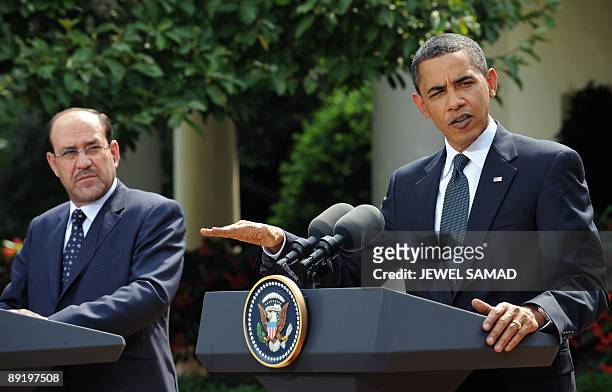 President Barack Obama answers a question as Iraqi Prime Minister Nuri al-Maliki looks on during a joint press conference following their meeting at...