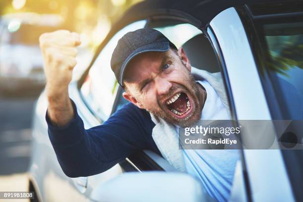 enraged male driver shakes fist, shouting through car window - road rage stock pictures, royalty-free photos & images
