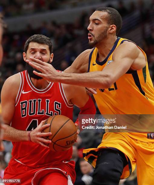 Nikola Mirotic of the Chicago Bulls is smacked in the face by Rudy Gobert of the Utah Jazz as he drives to the basket at the United Center on...