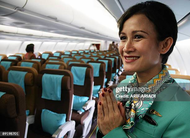 An Indonesian stewardess welcomes guests inside an Airbus A330-200 during the inauguration of the new Airbus A330-200 and Boeing 737-800 NG planes at...