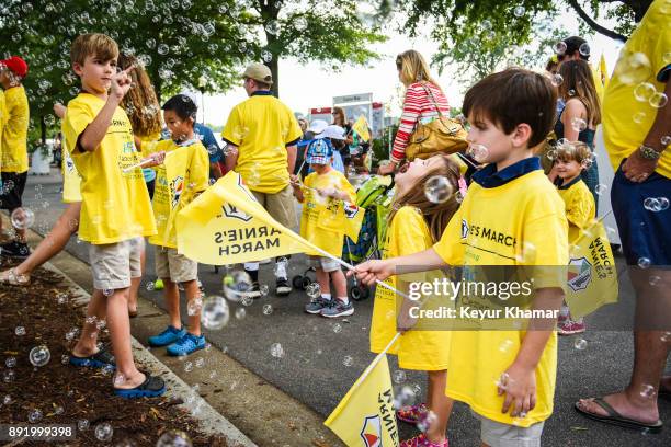 Children play with flags and bubbles during the Arnie's Army Charitable Foundation's Arnie's March held following practice for the TOUR Championship,...