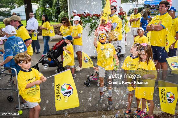 Children play with flags and bubbles during the Arnie's Army Charitable Foundation's Arnie's March held following practice for the TOUR Championship,...