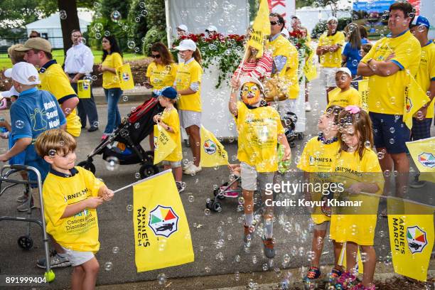 Children play with flags and bubbles during the Arnie's Army Charitable Foundation's Arnie's March held following practice for the TOUR Championship,...