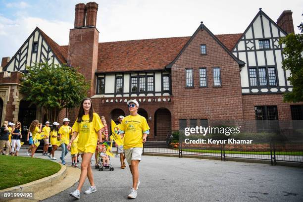 Participants walk past the clubhouse in Arnie's Army Charitable Foundation's Arnie's March held following practice for the TOUR Championship, the...