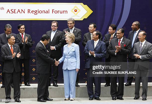 Secretary of State Hillary Clinton and Vietnam's Foreign Minister Pham Gia Khiem shake hands as foreign ministers and representatives from the...