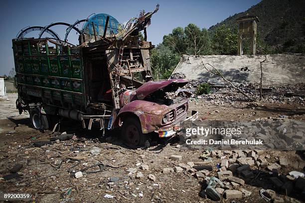 Vehicles lay destroyed at a petrol station in the village Umbela, after the Taliban engaged the Pakistan Miltary at a petrol station on July 16, 2009...