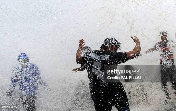 Onlookers and revellers throng the Marine Drive Promenade on the Arabian Sea front in Mumbai on July 23 as high tides lash the western Indian coast....