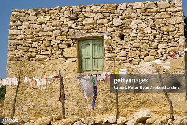 washing line in front of an old stone wall with small window at kastri on gavdos, greece, europe - gavdos ストックフォトと画像