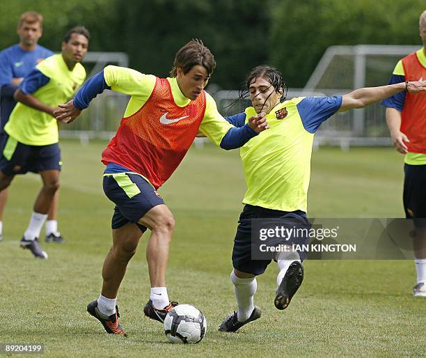 Barcelona's Spanish footballer Bojan Krkic Perez is challenged by Uruguayan footballer Martin Caceres during a team training session at Bisham Abbey...