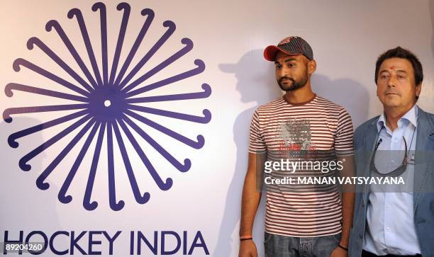 Indian hockey team captain Sandeep Singh and coach Jose Brasa pose with the newly unveiled team logo in New Delhi on July 23, 2009. A 23-member...