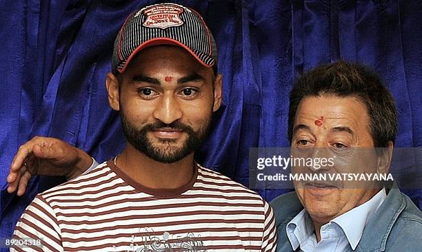 Indian hockey team captain Sandeep Singh and coach Jose Brasa pose prior to the unveiling of the new team logo in New Delhi on July 23, 2009. A...