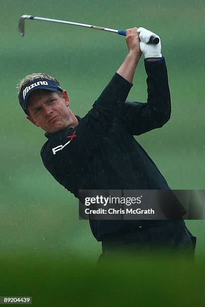 Luke Donald of England plays his second shot out of the bunker on the fifth hole before play was suspended due to inclement weather during round one...