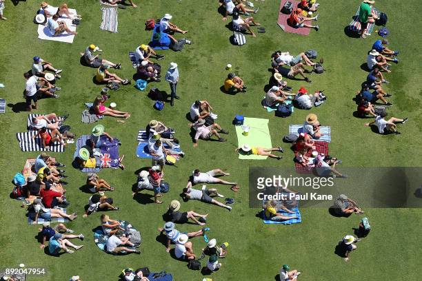 Spectators sit on the Western grass bank during day one of the Third Test match of the 2017/18 Ashes Series between Australia and England at WACA on...