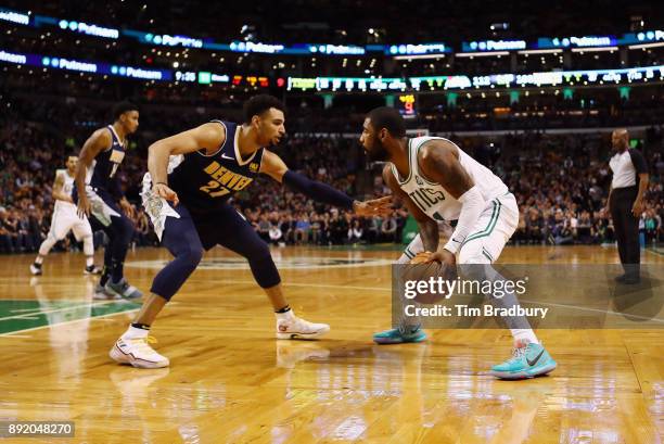 Kyrie Irving of the Boston Celtics handles the ball against Jamal Murray of the Denver Nuggets during the second half at TD Garden on December 13,...