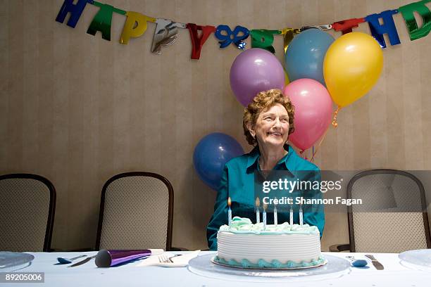 elderly woman at birthday party with decorations - senior birthday stock pictures, royalty-free photos & images