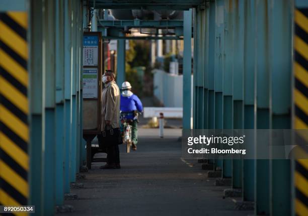 Man waits at a bus stop in the Keihin industrial area of Kawasaki, Kanagawa Prefecture, Japan, on Tuesday, Dec. 12, 2017. The Bank of Japan will...