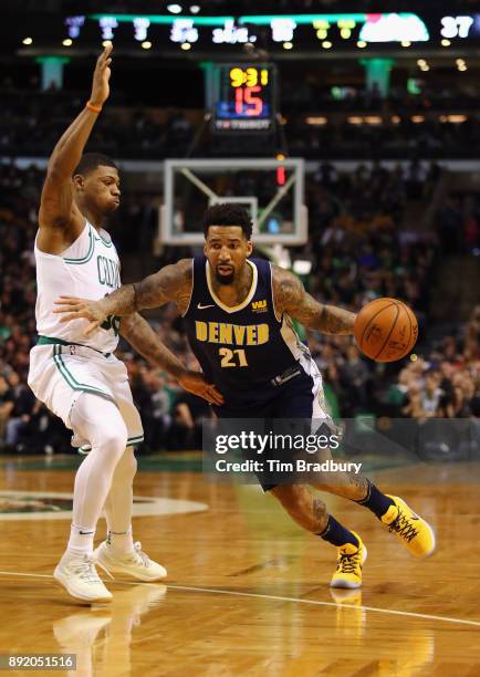 Wilson Chandler of the Denver Nuggets dribbles against Marcus Smart of the Boston Celtics during the first half at TD Garden on December 13, 2017 in...