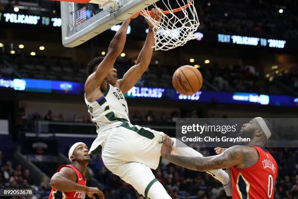 Giannis Antetokounmpo of the Milwaukee Bucks dunks the ball over DeMarcus Cousins of the New Orleans Pelicans at Smoothie King Center on December 13,...