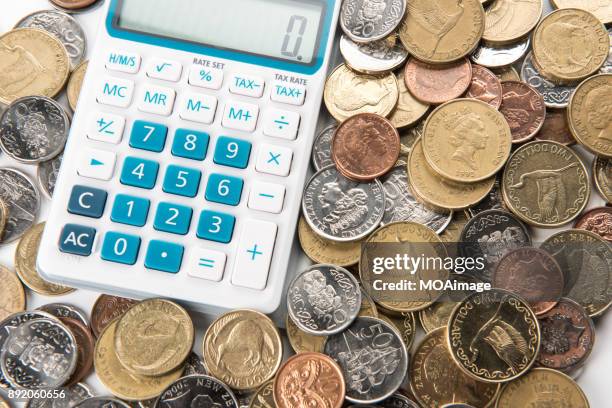 a calculator is on a pile of coins - the 2017 budget preparation stock pictures, royalty-free photos & images