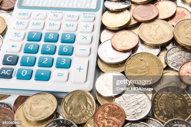 a calculator is on a pile of coins - the 2017 budget preparation stock pictures, royalty-free photos & images